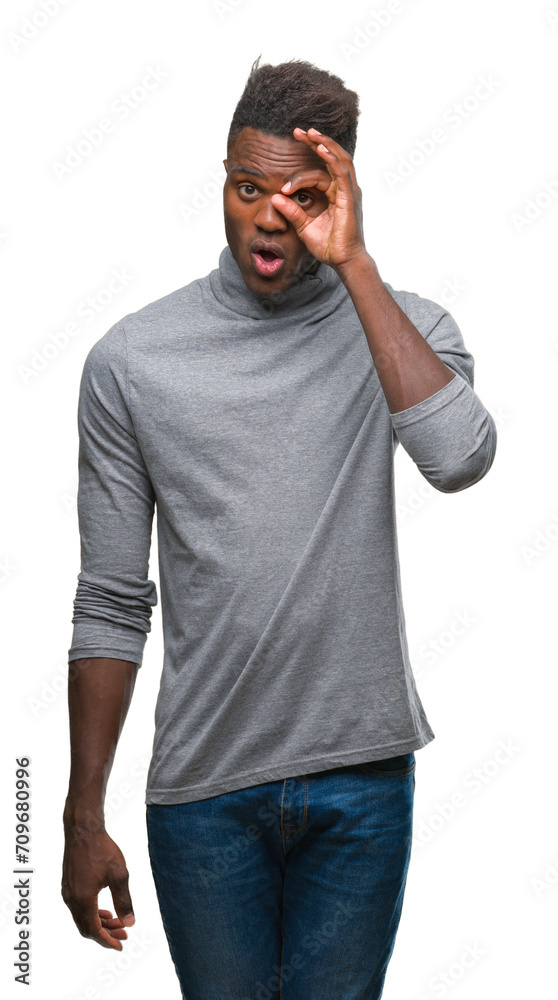 Poster Young african american man over isolated background doing ok gesture shocked with surprised face, eye looking through fingers. Unbelieving expression.