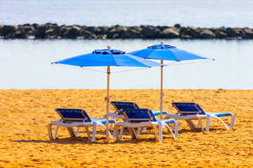 Beach umbrellas and sun loungers on the sunny coast