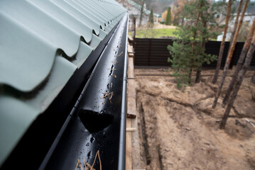 Black metal rain drainage gutter system © Sergey