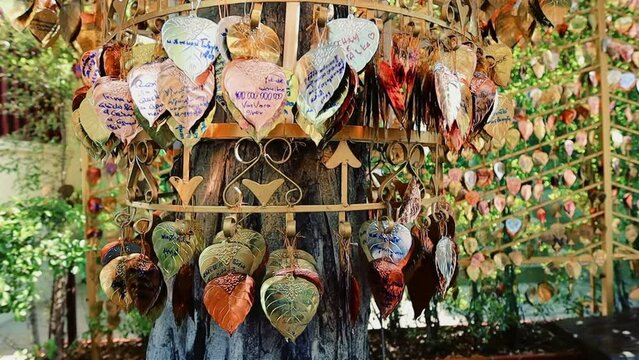 Messages and wishes written on the heart-shaped golden leaves hanging from the bells in Wat Saket temple Bangkok