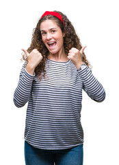 Fototapeta na wymiar Beautiful brunette curly hair young girl wearing stripes sweater over isolated background success sign doing positive gesture with hand, thumbs up smiling and happy. Looking at the camera