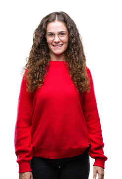 Beautiful brunette curly hair young girl wearing glasses and winter sweater over isolated background with a happy and cool smile on face. Lucky person.