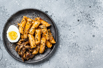 Korean Tteokbokki, Topokki fried rice cake stick in Hot and spicy sauce. Gray background. Top view. Copy space