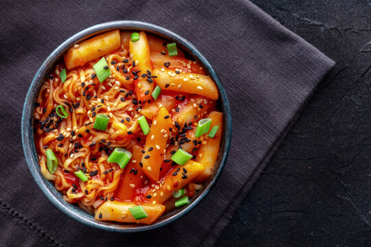 Rabokki, tteokbokki or topokki with ramen, Korean street food, spicy rice cakes in red pepper gochujang sauce, overhead flat lay shot