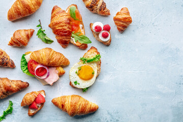 Croissant sandwich assortment. Various stuffed croissants, overhead flat lay shot. Rolls filled with ham, salmon, egg, etc, with copy space