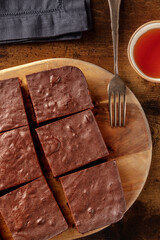 Chocolate brownie with tea, coffee cake, overhead flat lay view on a rustic wooden background