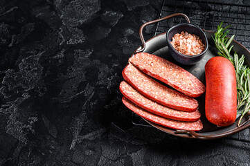 Turkish Sliced Sucuk beef meat sausage ready for cooking. Black background. Top view. Copy space