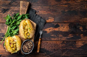 Kumpir, baked Jacket potatoes stuffed with cheese, bacon, salty cucumber, herbs and butter. Wooden...