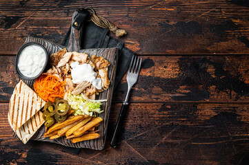 Kebab, Shawarma, Gyro grilled meat with french fries and vegetables on a wooden board. Wooden background. Top view. Copy space