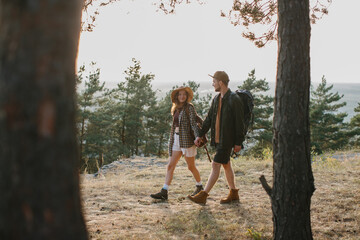 Obraz premium A guy and a girl are walking together holding hands during a hike in the mountains.