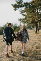 Young couple hiking on mountain. Back view.