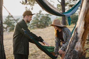 Guy and girl picking up hammock. Outdoor activities concept.