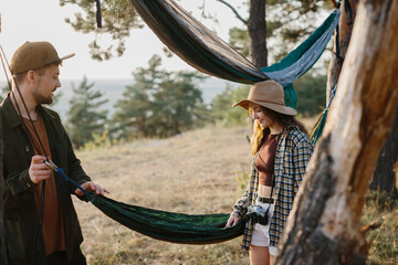 Guy and girl picking up hammock. Outdoor activities concept.