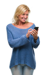 Middle age blonde woman sending message using smartphone over isolated background with a happy face standing and smiling with a confident smile showing teeth