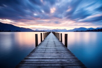 Fototapeta na wymiar Long Exposure of a Wooden Pier Extending into Calm Lake at Twilight