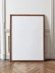 blank vertical wood poster frame standing on light wooden floor against white wall, empty picture frame mockup, blank wooden photo frame mock up