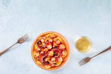 Pulpo a la gallega, Spanish octopus snack, Galician dish, overhead flat lay shot on a slate...