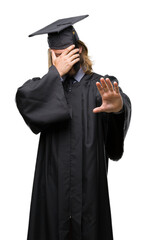 Young handsome graduated man with long hair over isolated background covering eyes with hands and doing stop gesture with sad and fear expression. Embarrassed and negative concept.