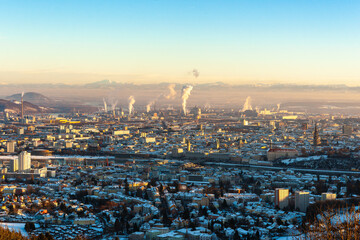 Skyline Linz Industriegebiet im Winter schneegedeckt bei Sonnenuntergang