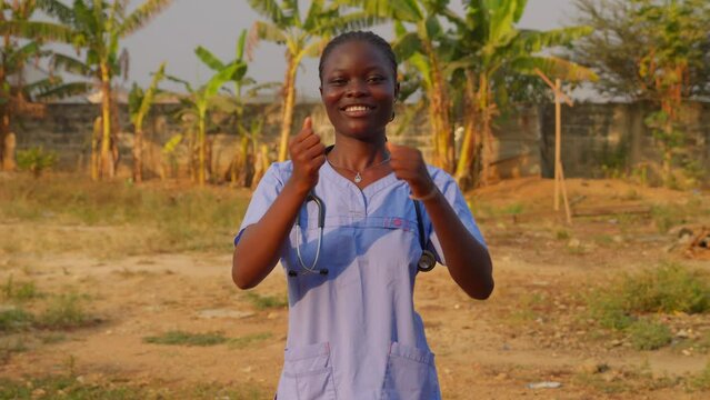 africa female nurse doctor saying I love you with gesture sign language in front of camera happily smiling 