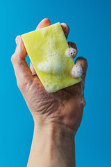 Dish detergent. Washing sponge in a person's hand