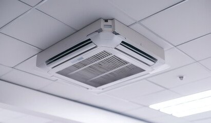 Ceiling mounted cassette type air conditioner and modern lamp light on white ceiling. duct air conditioner for home or office.