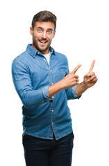 Young handsome man over isolated background smiling and looking at the camera pointing with two hands and fingers to the side.