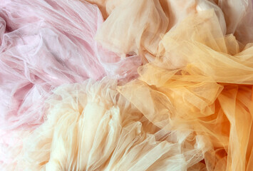 Top view abstract background of crumpled peach and pink chiffon.