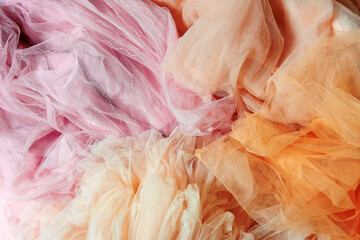 Top view abstract background of crumpled peach and pink chiffon.