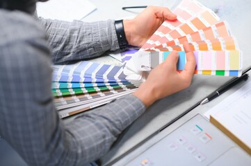 Typographer standing with color swatches at the printing manufacturing