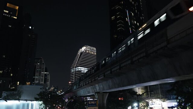 Train moving above ground between buildings, BTS skytrain city subway, modern urban view of bangkok thailand