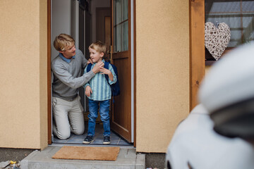 Boy getting ready for school, putting on shoes, getting dressed. Father taking son to school,...