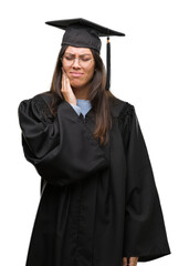 Young hispanic woman wearing graduated cap and uniform touching mouth with hand with painful expression because of toothache or dental illness on teeth. Dentist concept.