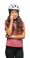 Young arab cyclist woman wearing safety helmet over isolated background looking stressed and nervous with hands on mouth biting nails. Anxiety problem.