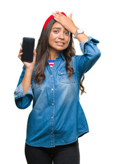 Obraz na płótnie Canvas Young beautiful arab woman showing screen of smartphone over isolated background stressed with hand on head, shocked with shame and surprise face, angry and frustrated. Fear and upset for mistake.