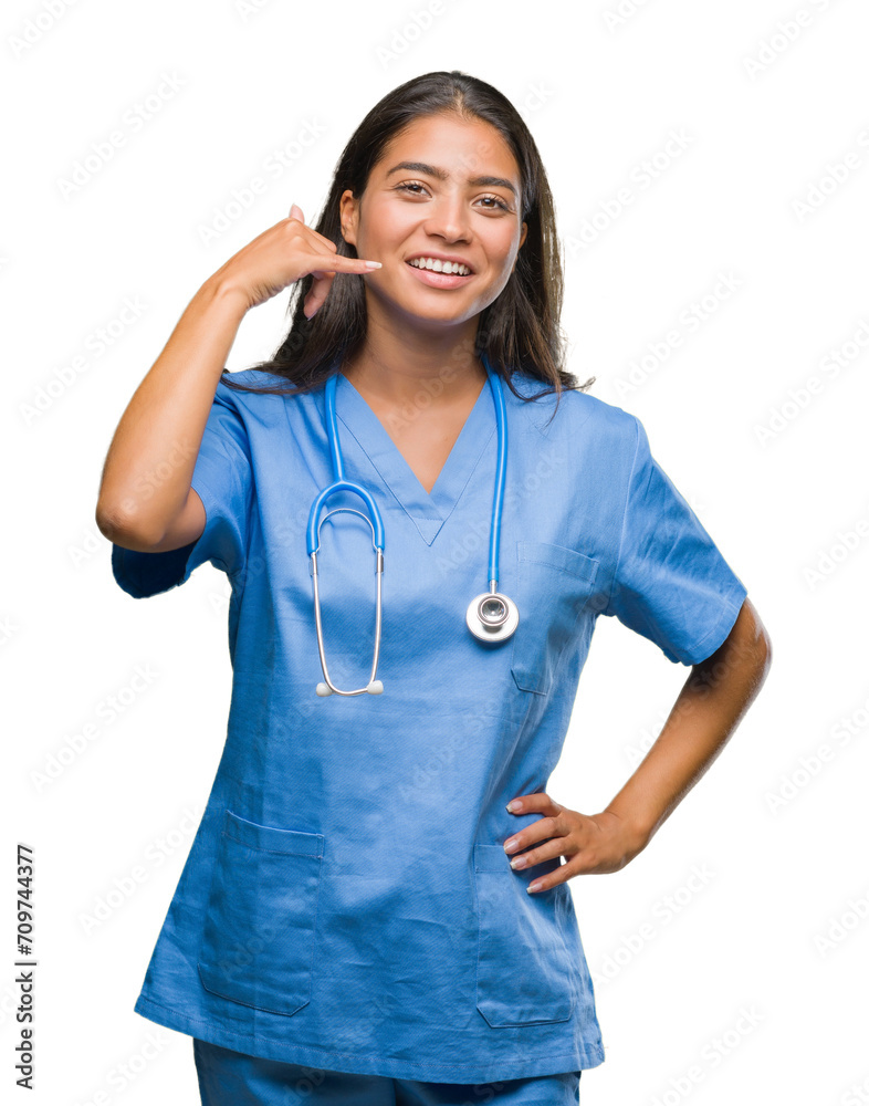 Wall mural Young arab doctor surgeon woman over isolated background smiling doing phone gesture with hand and fingers like talking on the telephone. Communicating concepts.