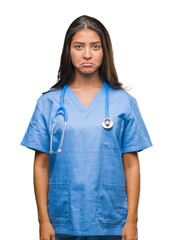 Young arab doctor surgeon woman over isolated background depressed and worry for distress, crying angry and afraid. Sad expression.