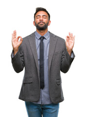 Adult hispanic business man over isolated background relax and smiling with eyes closed doing meditation gesture with fingers. Yoga concept.