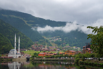 Mosque on Uzungol Mountain Lake, Trabzon, Turkey. Beautiful mountain landscape with clouds, lake, holiday houses, Turkey. Concept of travel and recreation