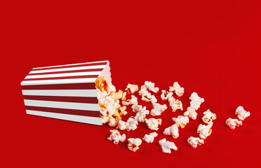 Obraz premium box with popcorn striped in different colors on a red background