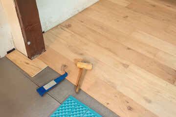 Newly laid parquet floor with wooden hammer and insulation floor.
