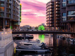 Canal with moored boats in Aker Brygge neighbourhood in Oslo, Norway. Typical example of Scandinavian architecture in the Aker Brygge area in Oslo