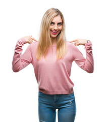 Obraz na płótnie Canvas Young beautiful blonde woman wearing pink winter sweater over isolated background looking confident with smile on face, pointing oneself with fingers proud and happy.