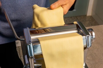 Production of homemade pasta - italian noodles in diy - Close-up of hands preparing the dough in a...