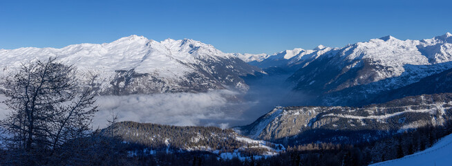 Obraz premium vue panoramique sur la vallée de la Maurienne dans les alpes. Les nuages recouvrent la vallée et les montagnes sont enneigées