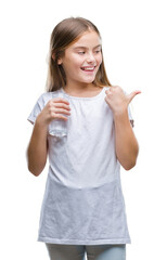 Obraz premium Young beautiful girl drinking glass of water over isolated background pointing and showing with thumb up to the side with happy face smiling