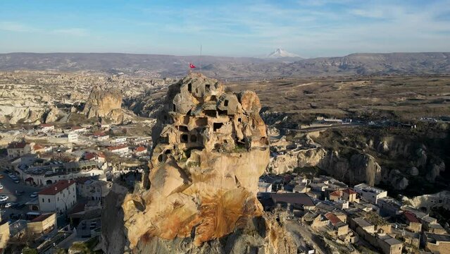 Aerial drone view of the Ortahisar Castle in Cappadocia, Turkey with the snow capped Mount Erciyes in the background.