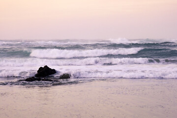Fototapeta premium Sunset with waves crashing against the rocks. Finisterre, Costa da Morte, Galicia, Spain