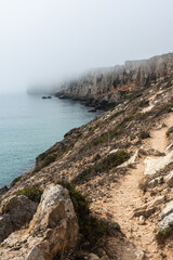 Dramatic cliffs in fog at Atlantic Ocean, Sagres, Algarve, Portugal