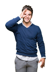 Young handsome business man over isolated background doing ok gesture with hand smiling, eye looking through fingers with happy face.